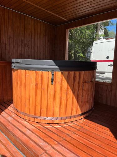 a wooden cabin with a wooden deck with a stove at Apartamenty Zielona Dolina nr 5 in Szteklin