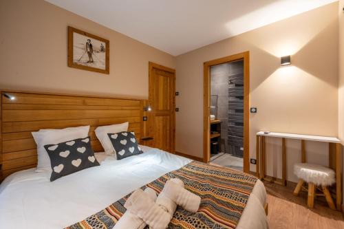 a bedroom with a large bed and a bathroom at Appartements Bétemps in Le Grand-Bornand
