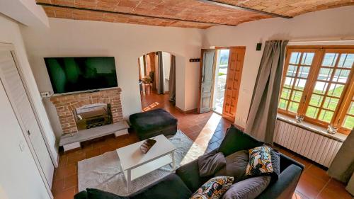 a living room with a couch and a fireplace at Villa Perla, hilltop location with pool in Calosso