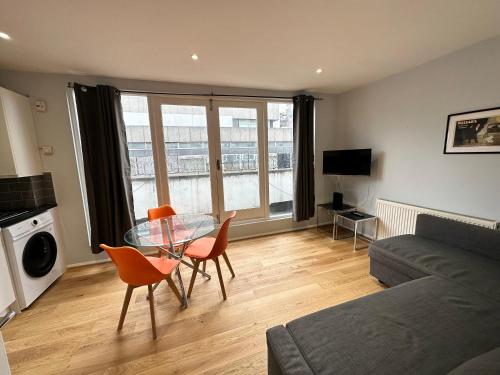a living room with a glass table and chairs at Maple Street Apartments in London