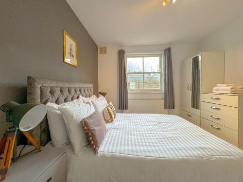 a bedroom with a white bed with pillows and a window at Maple Street Apartments in London