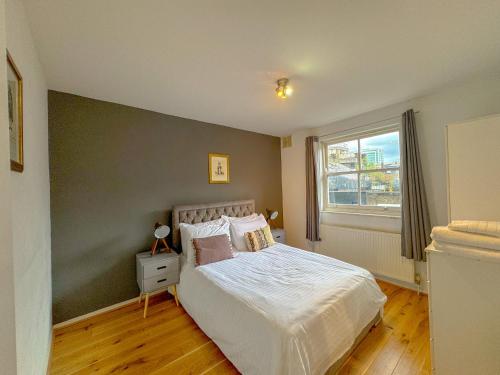 a bedroom with a white bed with a green wall at Maple Street Apartments in London