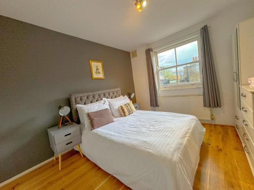 a bedroom with a white bed with a window at Maple Street Apartments in London