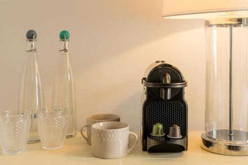 a black coffee maker sitting on a counter with cups at The Old Quay House Hotel in Fowey