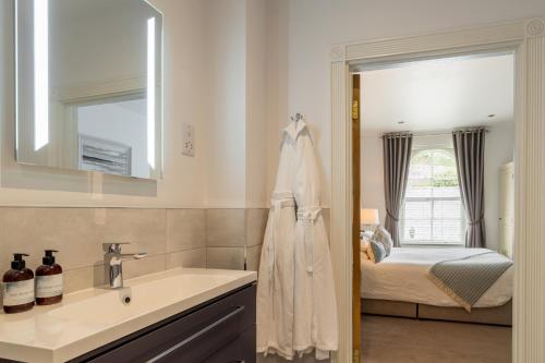 a bathroom with a sink and a mirror and a bed at The Old Quay House Hotel in Fowey