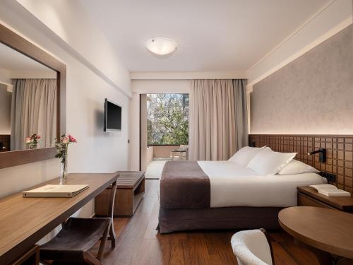 a hotel room with a bed and a desk at Civitel Akali Hotel in Chania Town
