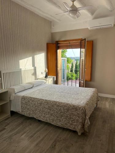 a bedroom with a bed and a large window at Apartamentos Vino Tinto y Restaurante Tomate Rosa in Adahuesca