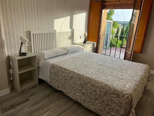 a bedroom with a bed and a balcony at Apartamentos Vino Tinto y Restaurante Tomate Rosa in Adahuesca