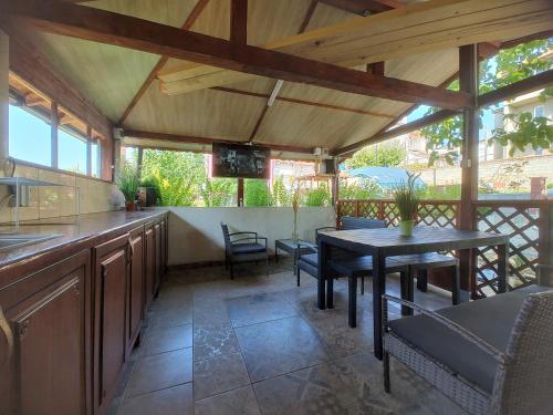 an outdoor kitchen with a table and chairs at Guest House 51 in Kranevo