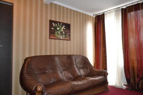 un sofá de cuero marrón en la sala de estar en Noclegi Capitto en Kostrzyn nad Odrą