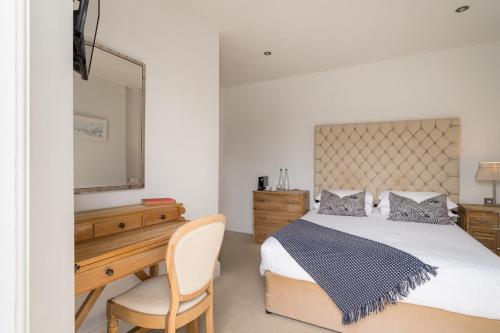a bedroom with a bed and a desk and a television at The Old Quay House Hotel in Fowey
