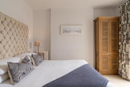 a bedroom with a bed and a wooden cabinet at The Old Quay House Hotel in Fowey