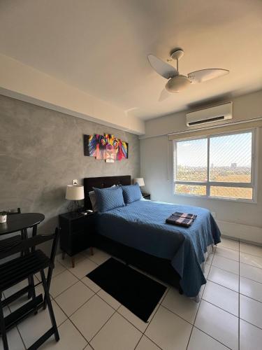 a bedroom with a bed and a table and a window at Studio completo e aconchegante in Ribeirão Preto