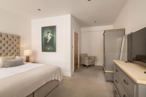 a bedroom with a bed and a television in it at The Old Quay House Hotel in Fowey