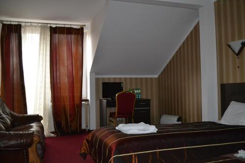 Habitación de hotel con cama y silla en Noclegi Capitto en Kostrzyn nad Odrą