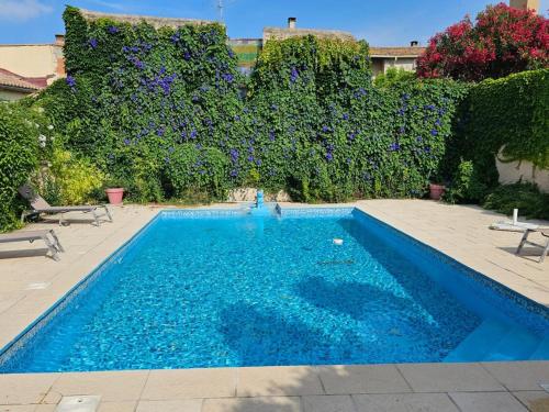 une piscine avec de l'eau bleue dans une cour dans l'établissement Occ34 - Capestang - Villa Quinlan, à Capestang