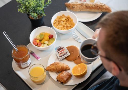 カルクフーにあるHôtel Inn Design Resto Novo Carquefouのテーブルの上に並べた朝食用の食材