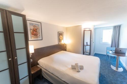 a hotel room with a bed with a cross on it at Hôtel Inn Design Resto Novo Carquefou in Carquefou