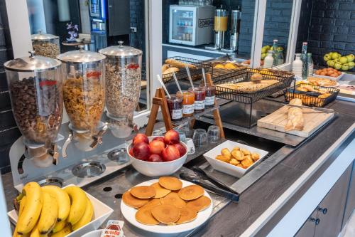 - un buffet composé de fruits et d'autres aliments sur un comptoir dans l'établissement Hôtel Inn Design Resto Novo Carquefou, à Carquefou