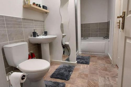 une salle de bain avec toilettes, lavabo et baignoire dans l'établissement Large 2 bed flat in Bolton, à Farnworth