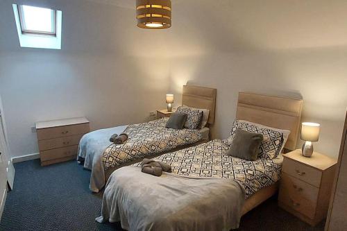 une chambre avec deux lits et deux tables de nuit et lampes dans l'établissement Large 2 bed flat in Bolton, à Farnworth