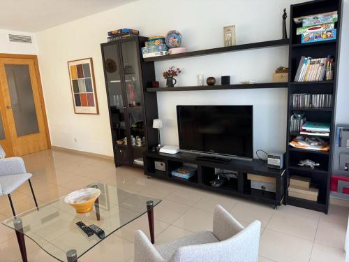 a living room with a tv and a glass table at Lindo piso residencial en salou centrico in Salou