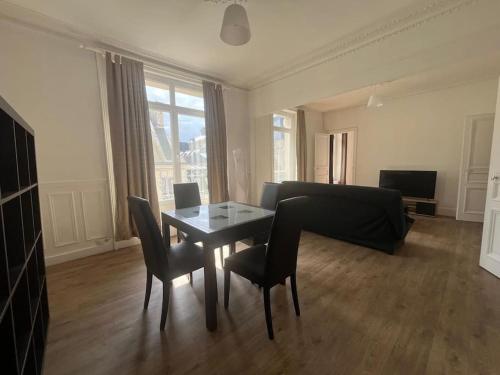 un salon avec une table, des chaises et un canapé dans l'établissement L'Entracte Cherbourgeois, à Cherbourg en Cotentin