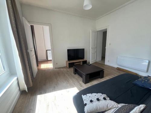 un salon avec un canapé et une télévision à écran plat dans l'établissement L'Entracte Cherbourgeois, à Cherbourg en Cotentin