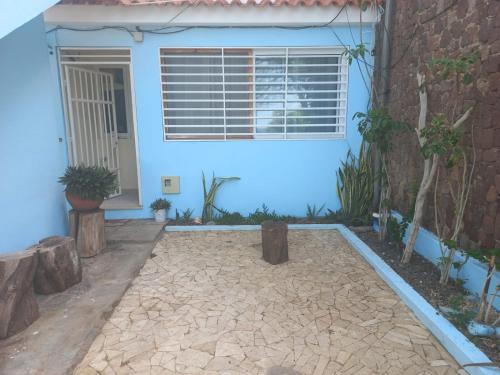 a blue house with a patio and a window at Brisa e Paz in Praia