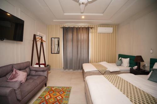 a living room with two beds and a couch at Green orchard skardu in Skardu