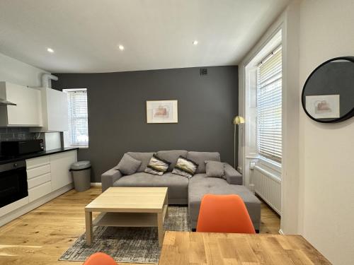 a living room with a couch and a table at Maple Street Apartments in London