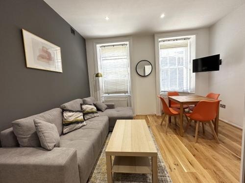 a living room with a couch and a table at Maple Street Apartments in London