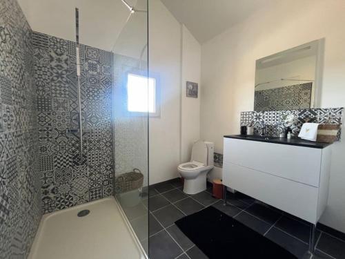 une salle de bain avec toilettes et douche en verre dans l'établissement Maison de charme, piscine et vue panoramique, à Mudaison