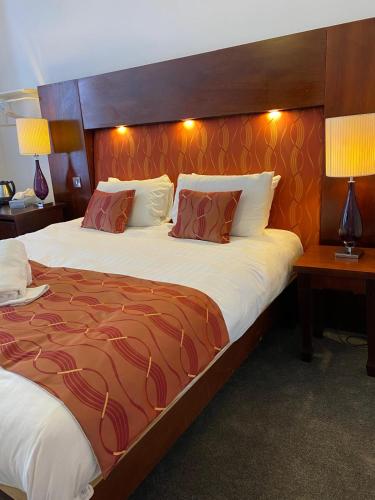 a bedroom with a large bed with a wooden headboard at The Bailey Hotel Blackpool in Blackpool