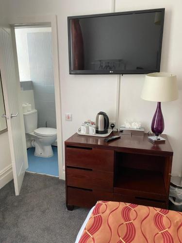 a hotel room with a desk with a television on the wall at The Bailey Hotel Blackpool in Blackpool