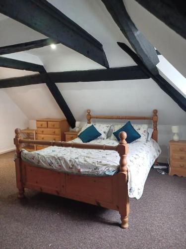a bedroom with a wooden bed with blue pillows at Amazing value, in great location in Plymouth