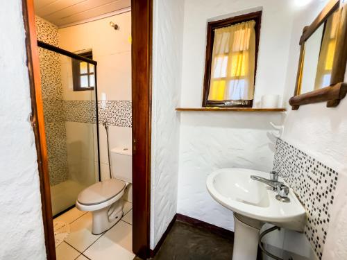 a bathroom with a toilet and a sink at Pousada da Trilha in Monte Verde