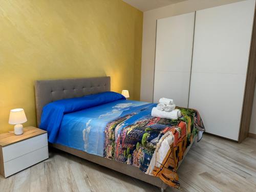 a bedroom with a bed with a blue comforter at Napul'è B&B in Boscotrecase