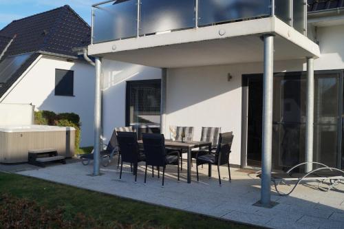 ゲーレン・レビンにあるVilla Waterfront am Seeの家の前にテーブルと椅子が置かれたパティオ