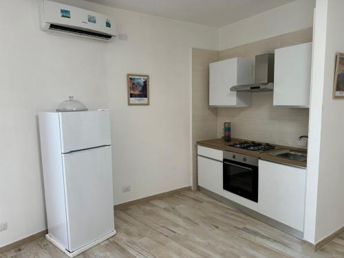 a kitchen with white appliances and a white refrigerator at Napul'è B&B in Boscotrecase