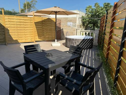 a black table and chairs with an umbrella on a patio at Napul'è B&B in Boscotrecase