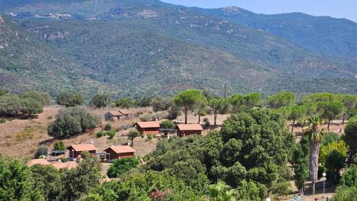une vue aérienne sur une ferme avec des montagnes en arrière-plan dans l'établissement Camping Les Couchants, à Casaglione