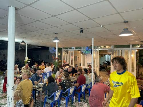 a group of people sitting at tables in a restaurant at Hoàng Sáng Residence & Restaurant in Ấp Mỹ Hải