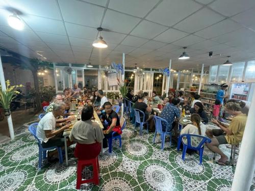 a group of people sitting at tables in a restaurant at Hoàng Sáng Residence & Restaurant in Ấp Mỹ Hải