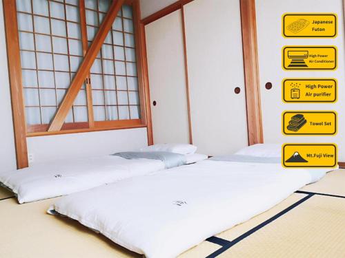 two beds in a room with signs on the wall at 安野月江苑 Anno Gekkouen FUJI in Fujiyoshida