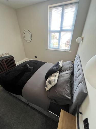 a bed in a room with a couch and a window at Stunning 2 Bedroom Ground Floor Sea View Apartment in Llandrillo-yn-Rhôs