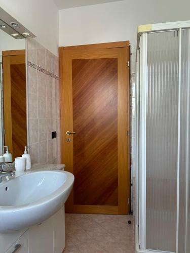 a bathroom with a sink and a wooden door at B&B Gioia in Salsomaggiore Terme