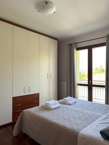 a bedroom with a bed with white cabinets and a window at B&B Gioia in Salsomaggiore Terme
