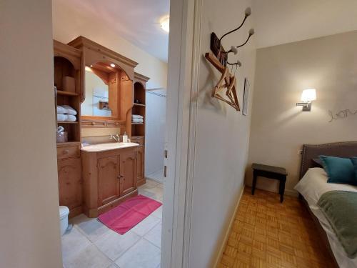 La salle de bains est pourvue d'un lavabo et d'un lit dans la chambre. dans l'établissement La Maison de Marie, à Kérien