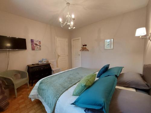 une chambre avec un grand lit avec des oreillers bleus dans l'établissement La Maison de Marie, à Kérien